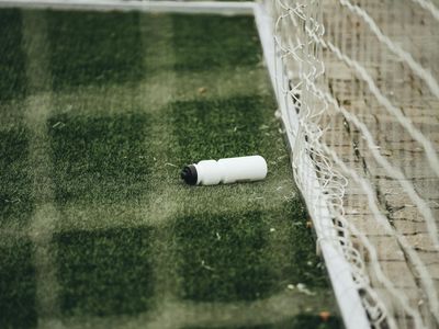 Close up of a water bottle on a green grass field.