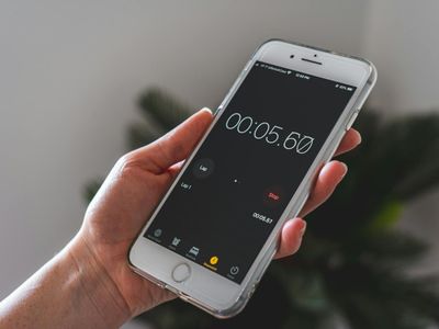 Hand holding a stopwatch against a blurred background.
